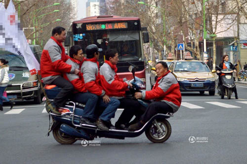 5名男子挤1辆电动车在街头行驶引围观